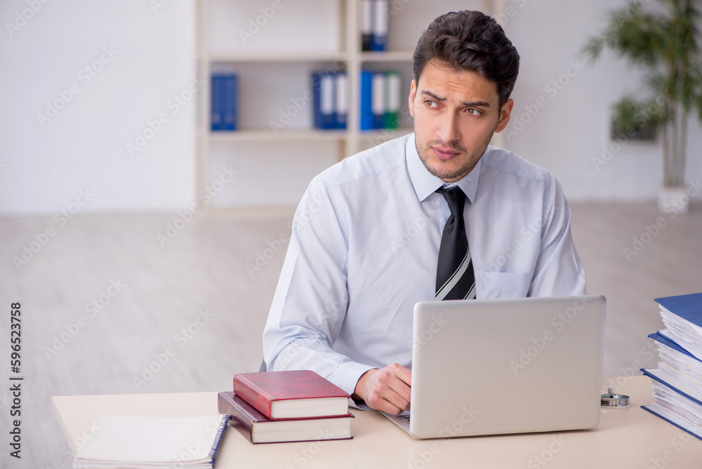 Young male employee working in the office Young male employee working in the office
