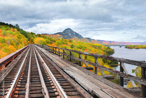 Fototapete Fall scene on train trestle with mountain in foreground