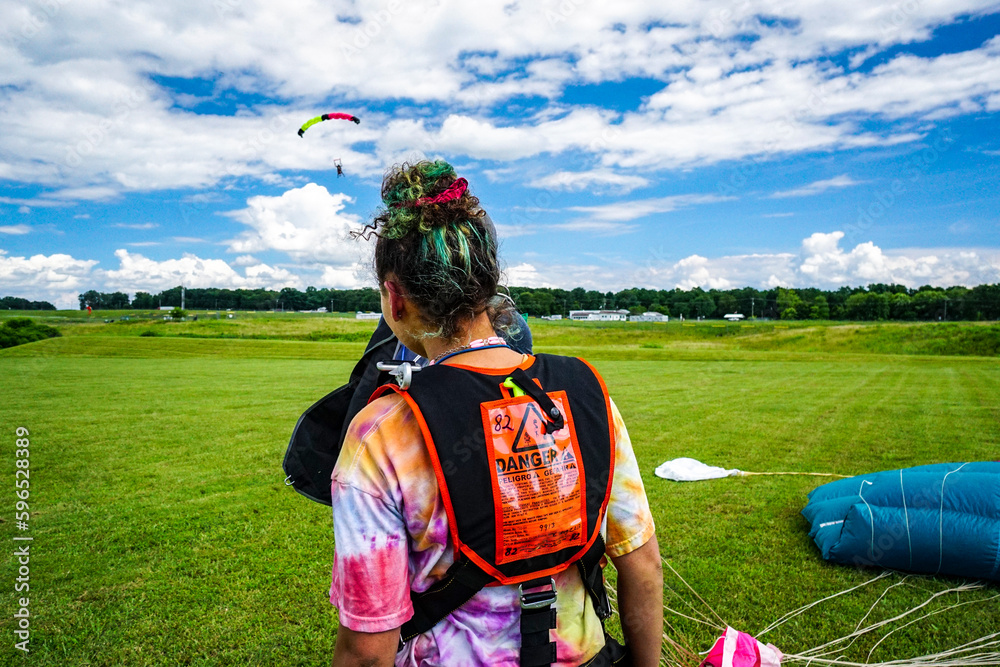 Tandem skydive student watches landing parachute