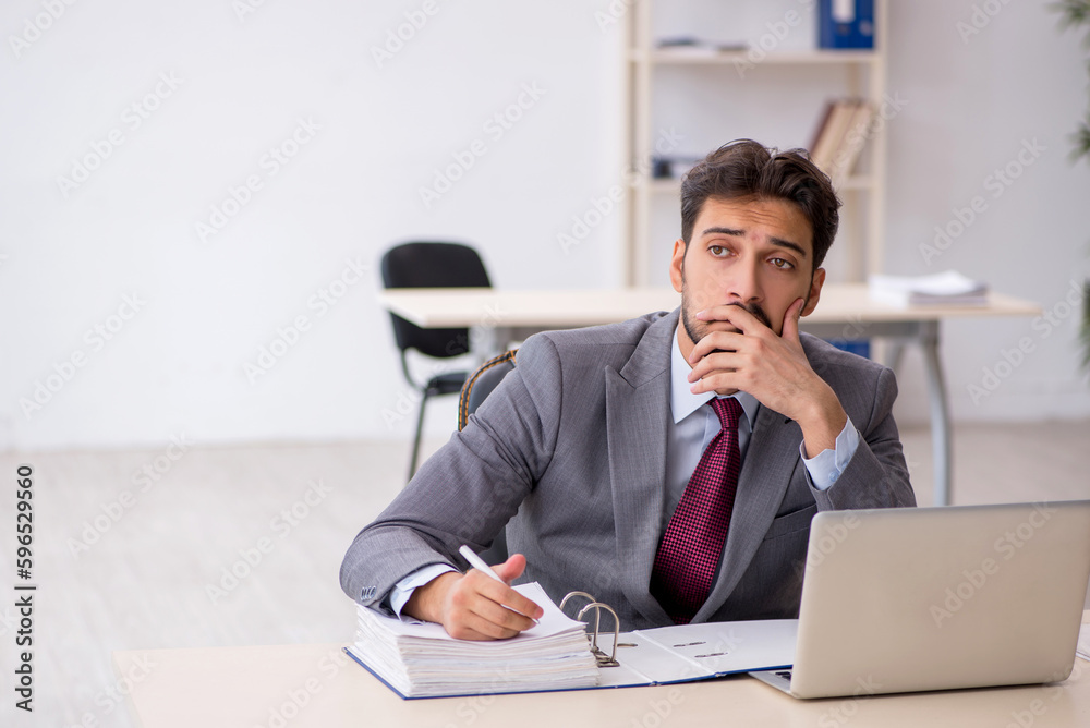 Young male employee working in the office Young male employee working in the office