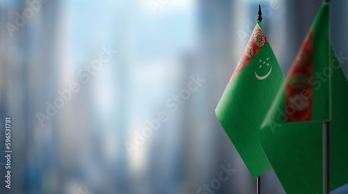 Small flags of the Turkmenistan on an abstract blurry background