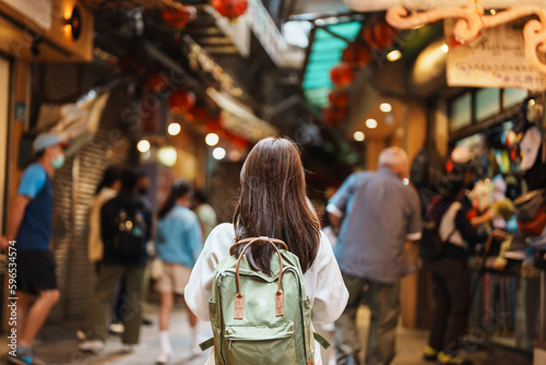woman traveler visiting in Taiwan, Tourist with hat and backpack sightseeing and shopping in Jiufen Old Street market. landmark and popular attractions near Taipei city. Travel and Vacation concept