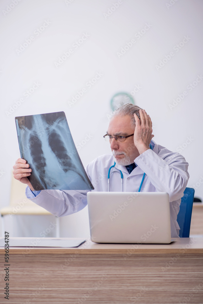 Old male doctor radiologist working in the clinic Old male doctor radiologist working in the clinic