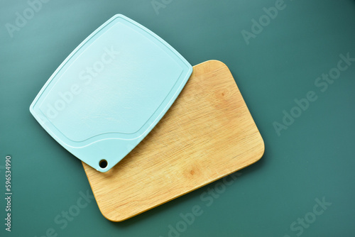 blue and brown wooden cutting board on green background, equipment for cooking in the kitchen