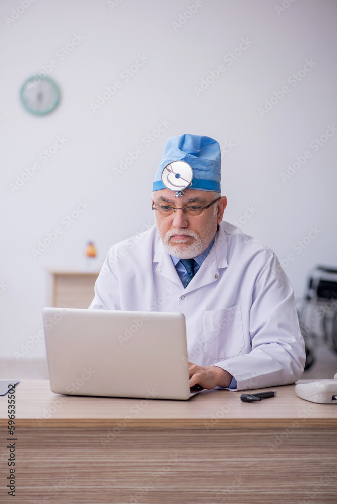 Old male docror otolaryngologist working in the clinic Old male docror otolaryngologist working in the clinic