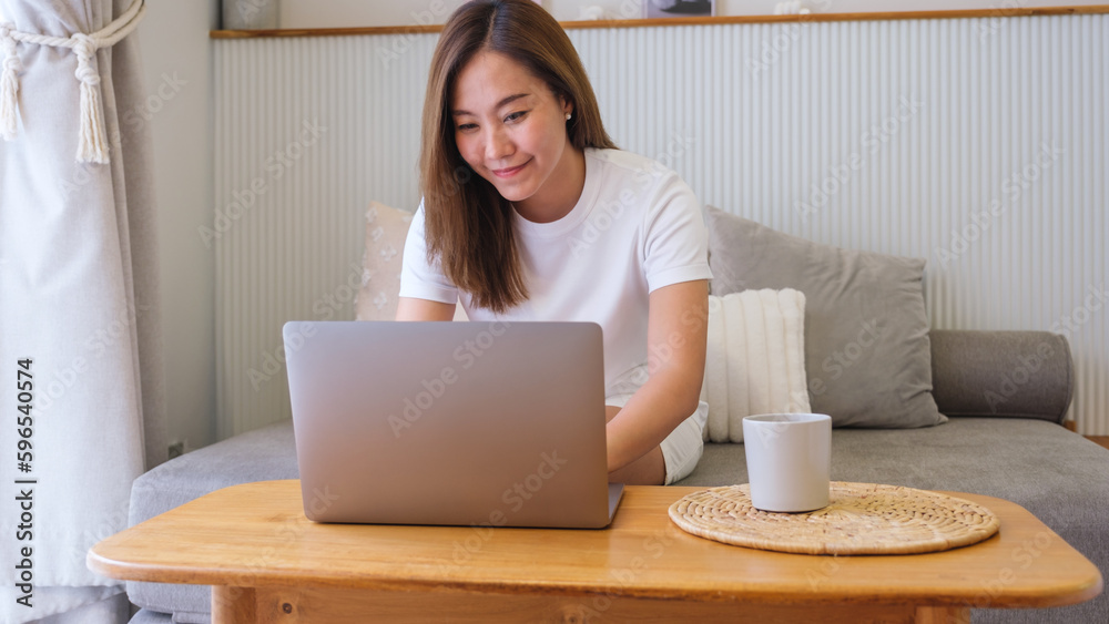 Portrait image of a young woman working on laptop computer at home Portrait image of a young woman working on laptop computer at home
