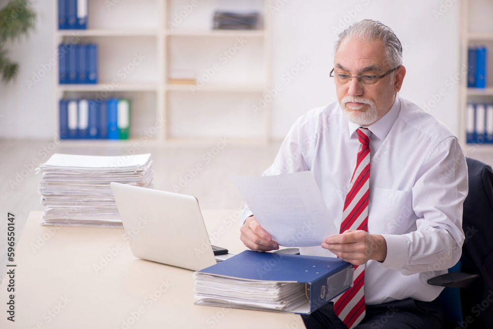 Old male employee and too much work at workplace Old male employee and too much work at workplace