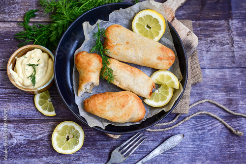   Allasca Pollock Fish  Bites in a crispy Tempura  Batter.Fish and chips .Close up of   crispy breaded  deep fried fish fingers with breadcrumbs s erved with remoulade sauce and  lemon photo