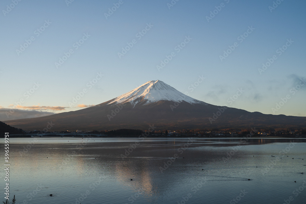 the landscape mountain in Japan fuji mountain reflects the Kawaguchi Lake surrounded by blue sky and snow on the top of the volcano, a beautiful view of the japan volcano on the sightseeing vacation