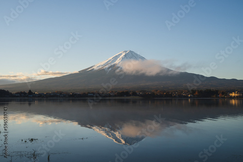 the landscape mountain in Japan fuji mountain reflects the Kawaguchi Lake surrounded by blue sky and snow on the top of the volcano  a beautiful view of the japan volcano on the sightseeing vacation