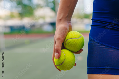 Tennis player holding balls in hands