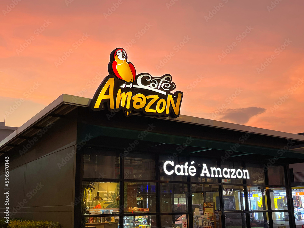 Facade of the Amazon Cafe building on background of bright orange sunset skies. Logo colored