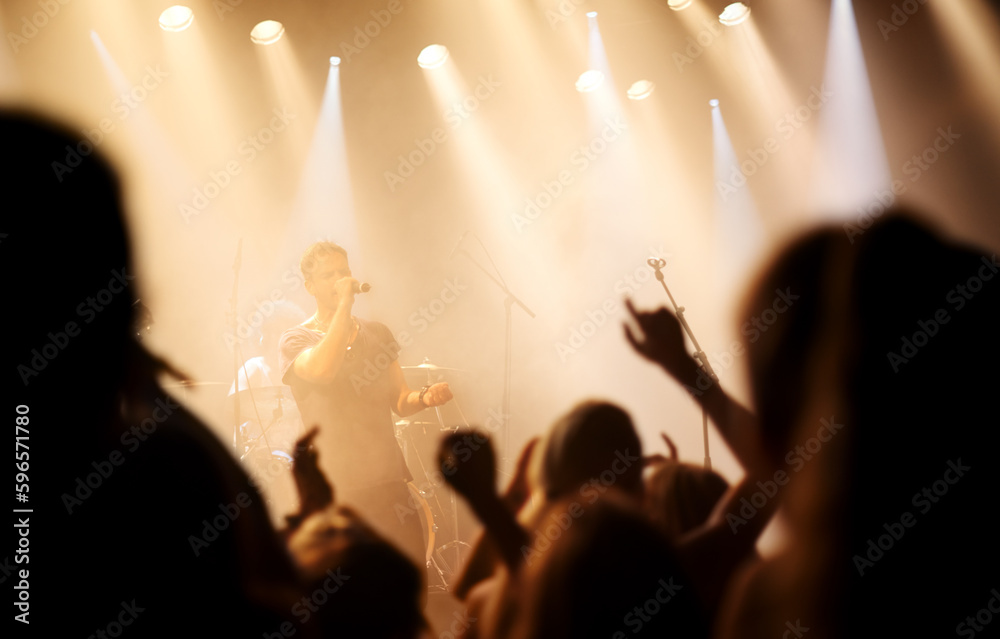 Music festival, concert or people singing at night performance for gen z party, nightclub lights and dancing. Rock band on stage at event with crowd dance, audience group or fans energy in silhouette