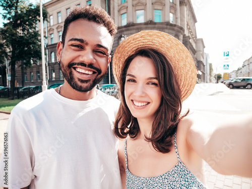 Smiling beautiful woman and her handsome boyfriend. Woman in casual summer clothes. Happy cheerful family. Female having fun. Sexy couple posing in the street at sunny day. Take selfie photos