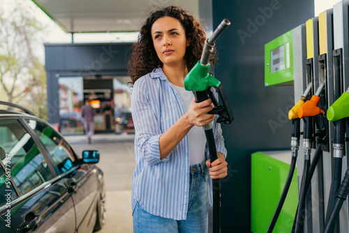 A student puts fuel in his car before leaving home for college photo