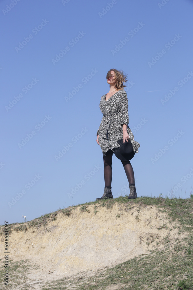 Serie of photos of female model in boho viscose floral dress and hat with clear blue sky behind. Outdoor fashion portrait with natural light. Serie of photos of female model in boho viscose floral dress and hat with clear blue sky behind. Outdoor fashion portrait with natural light.
