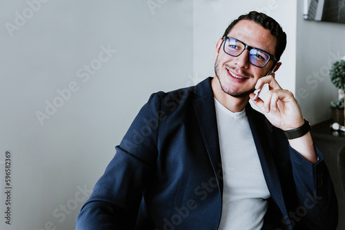 young latin businessman working and using laptop or computer in smart casual clothes at office in Mexico, hispanic people