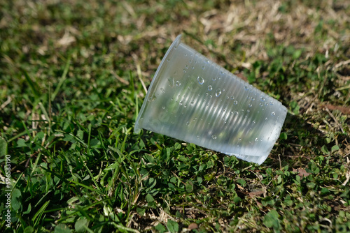 Sinle usage Plastic cup on grass environment pollution concept idea photo