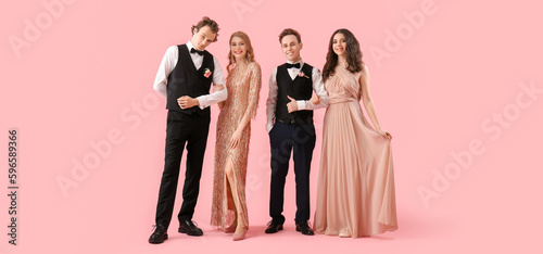 Beautiful couples dressed for prom on pink background