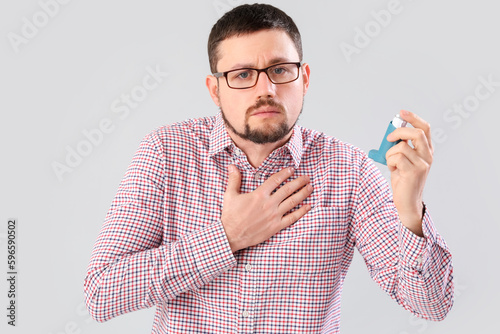 Sick man with inhaler on li...