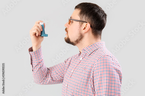 Man with inhaler on light b...