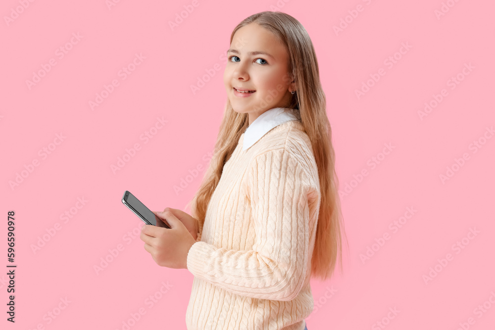 Little girl using mobile phone on pink background Little girl using mobile phone on pink background