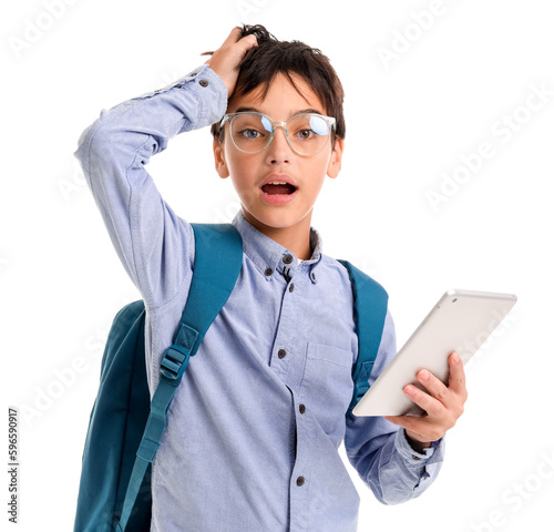 Stressed little schoolboy using tablet computer on white background