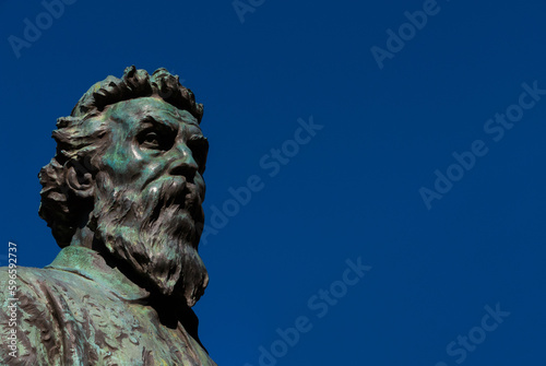 Benvenuto Cellini, a famous Italian Renaissance goldsmith and sculptor. Old bronze monument erected in 1901 on Ponte Vecchio (Old Bridge) in Florence (with blue sky and copy space) photo
