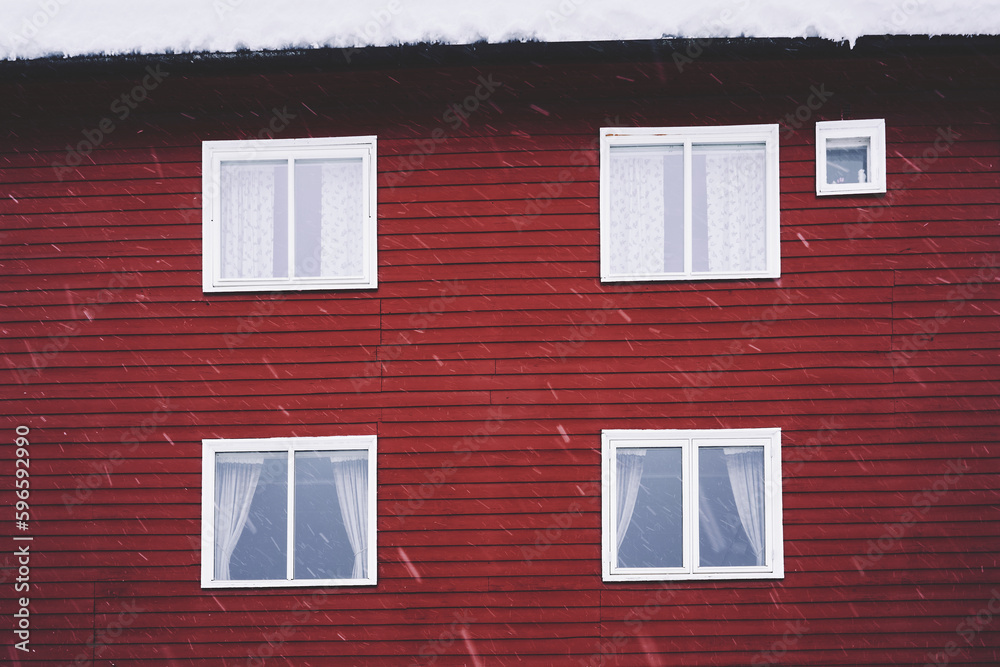 snowy winter weather and a red wooden wall