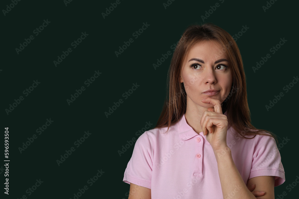 Thoughtful young woman in pink t-shirt on green background Thoughtful young woman in pink t-shirt on green background