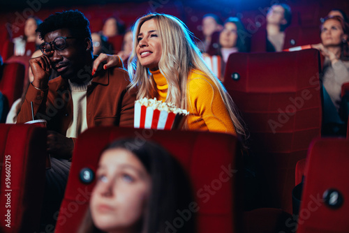 Fotografia Multiethnic couple crying in movie theater.