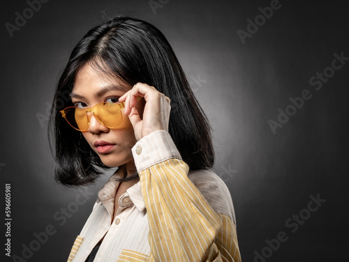 A portrait of a casual fashion-style Asian (Chinese Indonesian) Girl posing dan dancing with a Hip hop style. Isolated on a black background photo