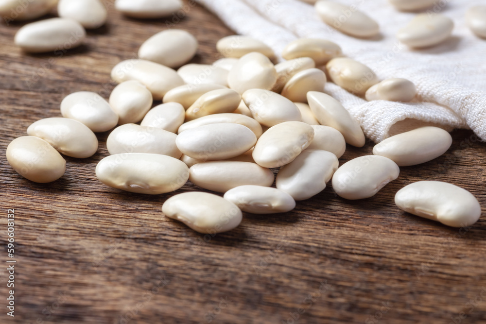 Heap of white beans on wooden table