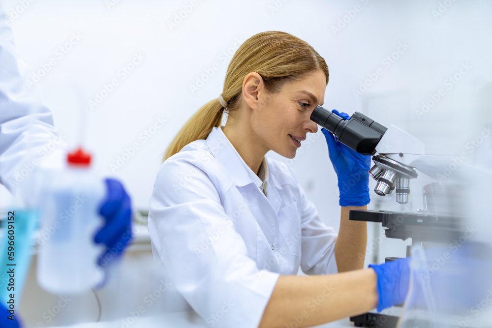 Scientist looking under microscope, doing analysis of test sample, ambitious biotechnology specialist Scientist looking under microscope, doing analysis of test sample, ambitious biotechnology specialist