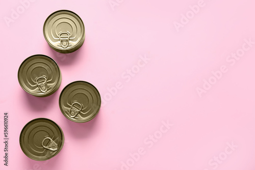 Tin cans with fish on pink background