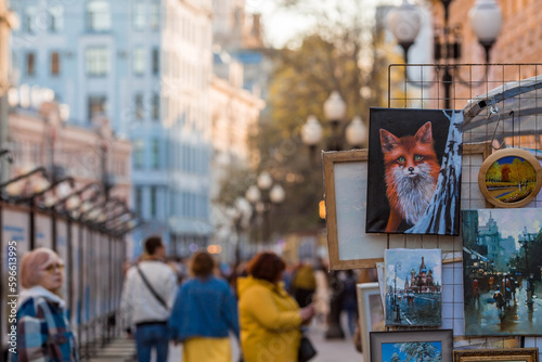 Old Arbat and paintings by artists. People are walking in the city center. Russia, Moscow 2023