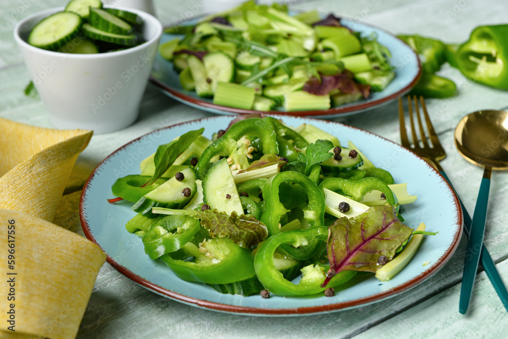 Plates of salad with green vegetables and ingredients on wooden background Plates of salad with green vegetables and ingredients on wooden background