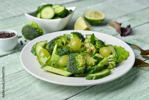 Plate of salad with vegetables and ingredients on green wooden background