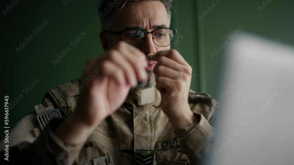 Soldier with glasses working with laptop in home. Everyday life of a military man in reserve. Work and communication online