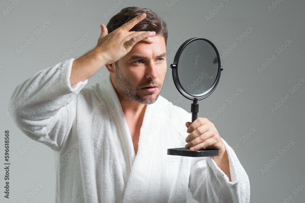 Mens beauty cosmetics, male beauty and skincare. Morning healthcare and hygiene for man. Perfect beauty skin. Handsome millennial man after shower apply nourishing facial cream or mask on skin. Mens beauty cosmetics, male beauty and skincare. Morning healthcare and hygiene for man. Perfect beauty skin. Handsome millennial man after shower apply nourishing facial cream or mask on skin.