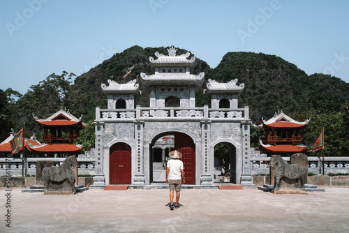 Young traveler in a hat visits a temple in Vietnam