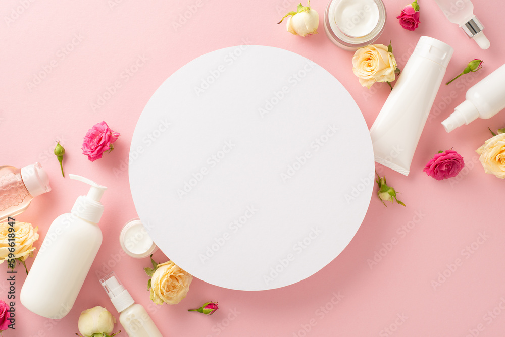 Tender flower skincare concept. Top view flat lay of pump bottle, pipette, cream bottles and tubes with pink flowers on pastel pink background with empty circle for text or branding