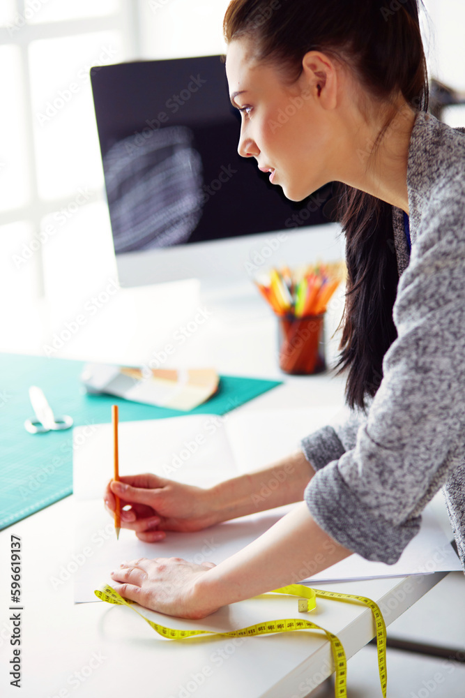 Fashion designers working in studio standing near desk. Fashion designers working in studio standing near desk.