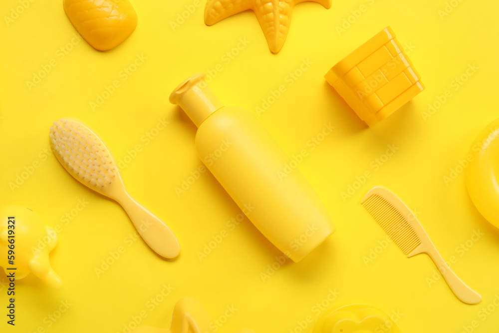 Fototapeta premium Sunscreen cream for baby with beach accessories on yellow background