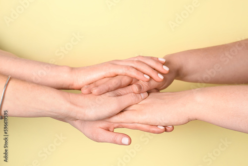 Wallpaper Mural Women putting hands together on yellow background. Friendship concept Torontodigital.ca