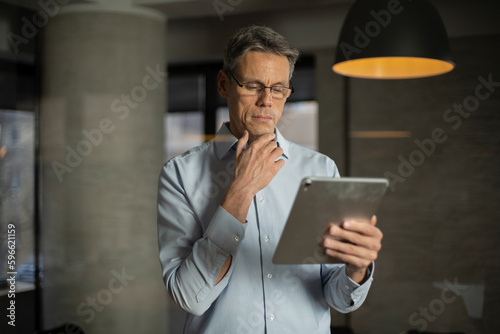Portrait of businessman in office. Man using digital tablet. Businessman having video call..