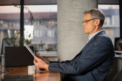 Portrait of businessman in office. Man using digital tablet. Businessman having video call..