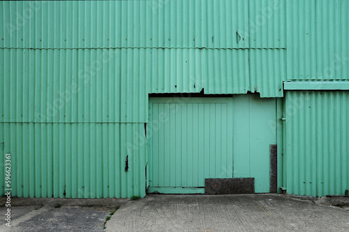 Green corrugated metal barn with closed doors