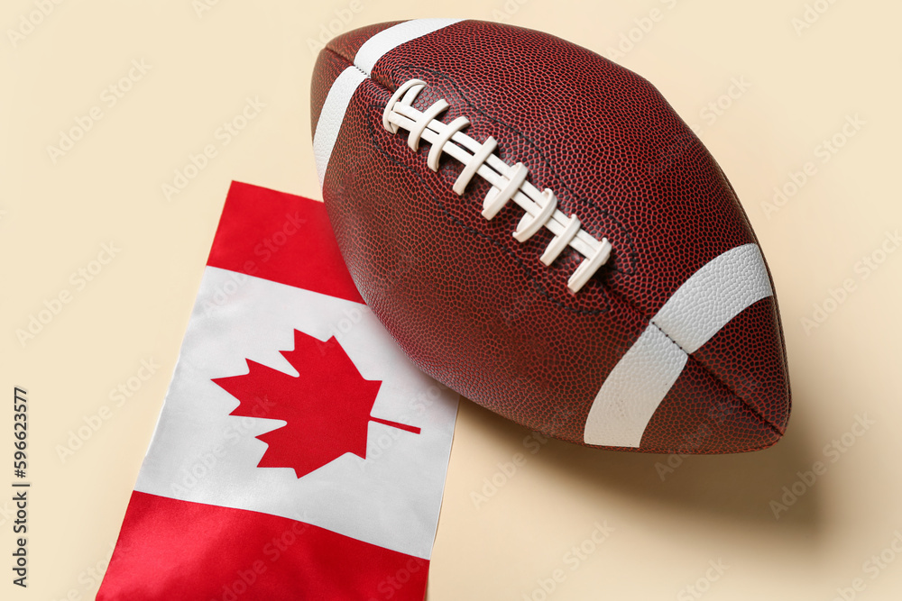 Obraz premium Flag of Canada with rugby ball on beige background, closeup