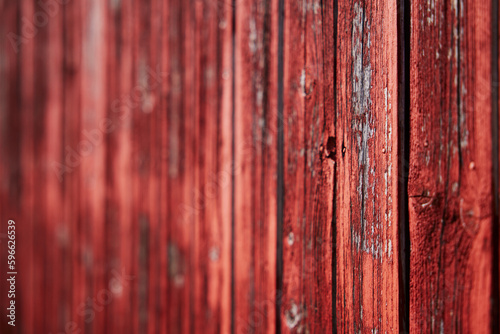 old red barn wood panel red paint texture that is flaking off low depth of field photo